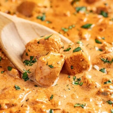 Butter chicken sauce with wooden spoon