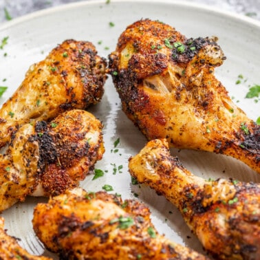 Air fryer chicken legs on a dinner plate.