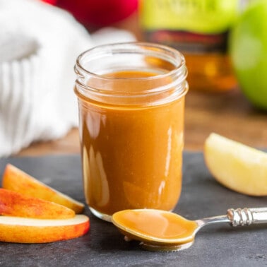 A glass jar filled with apple bourbon caramel sauce.