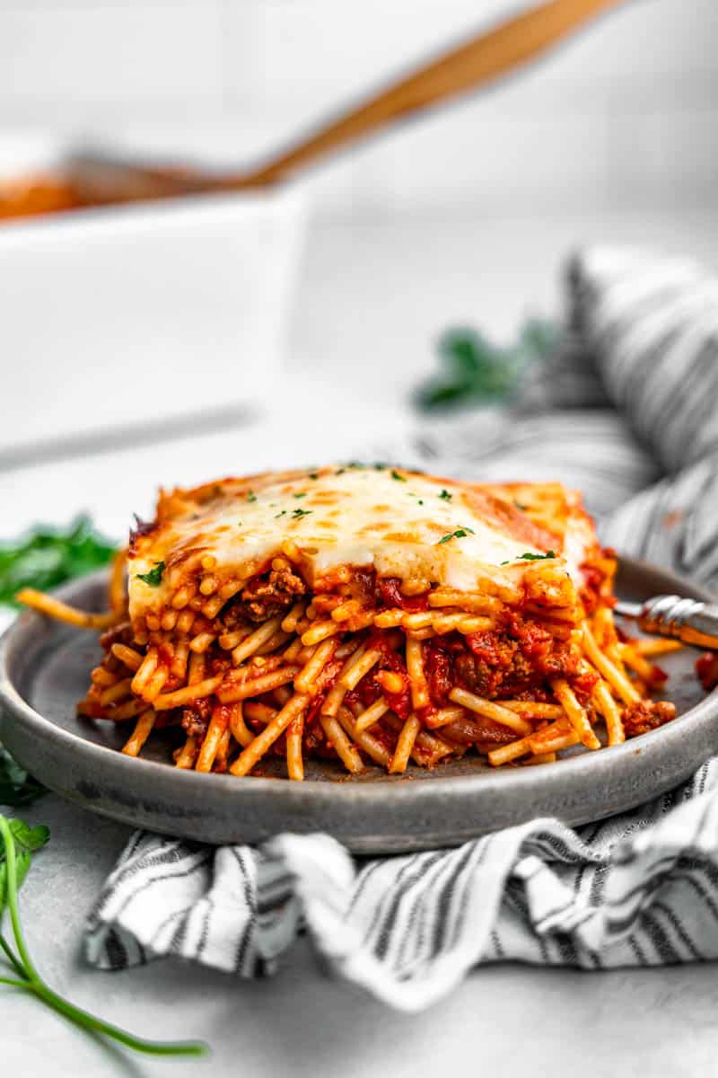 A close up view of a slice of baked spaghetti on a gray plate.