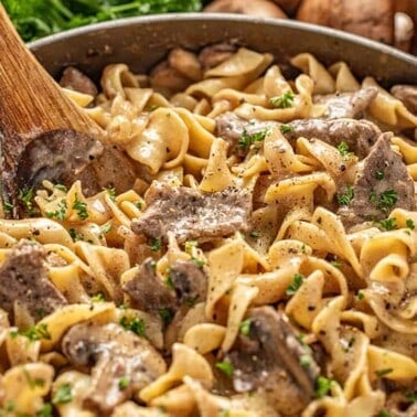 Beef stroganoff in pan with wooden spoon