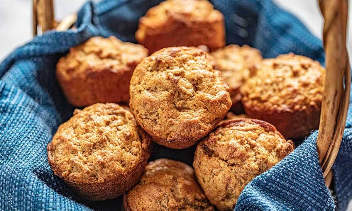 Bran muffins in a basket with a blue cloth underneath