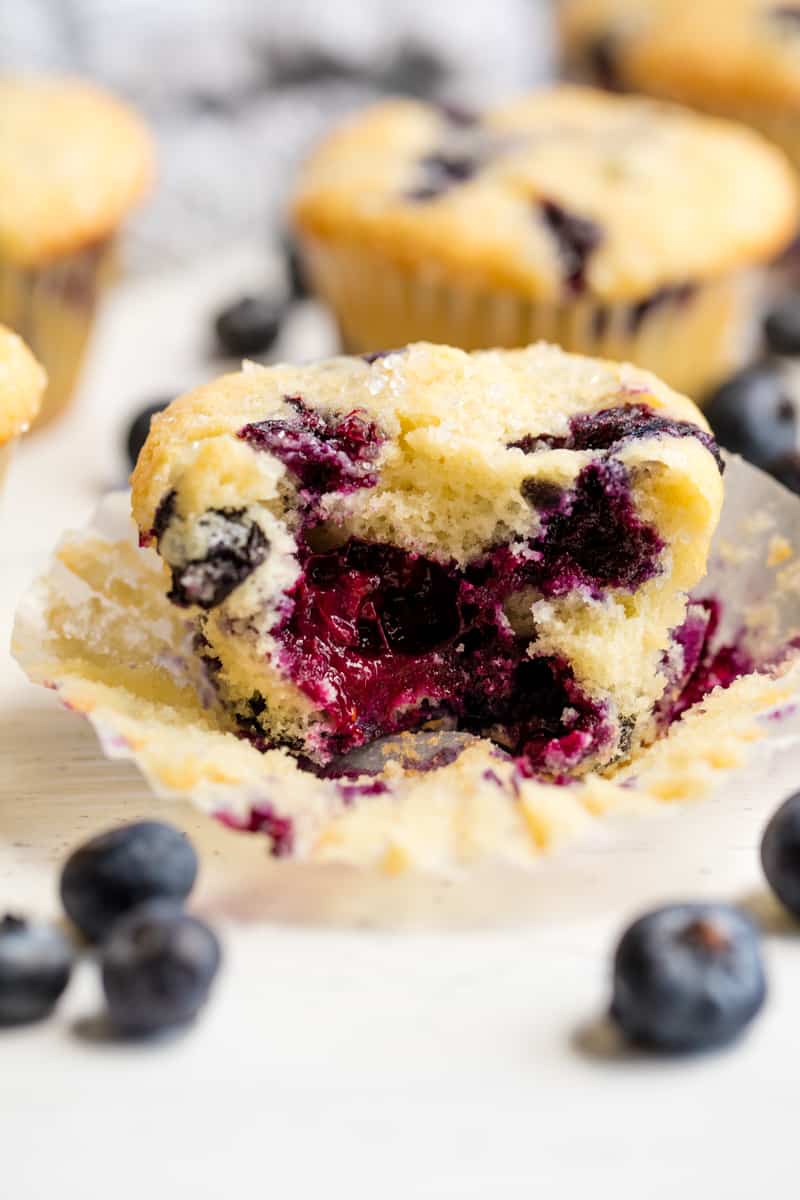 Blueberry Muffin with the wrapper undone and a bite taken out of the muffin.