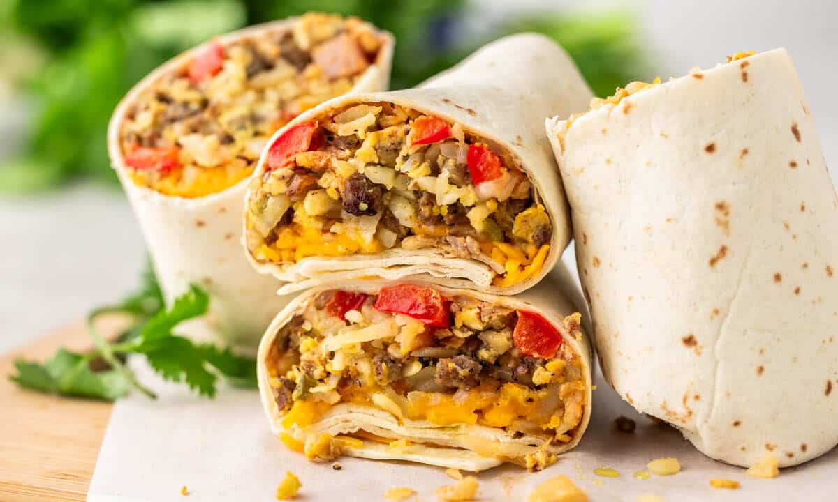 Breakfast burrito halves that have been stacked on top of each other on a kitchen counter.