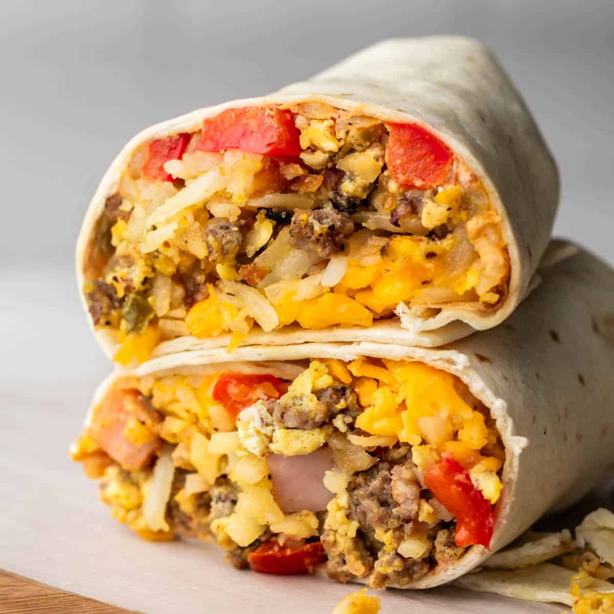 Close up view of a breakfast burrito cut in half.