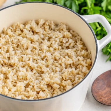 Brown rice in a large white saucepan.