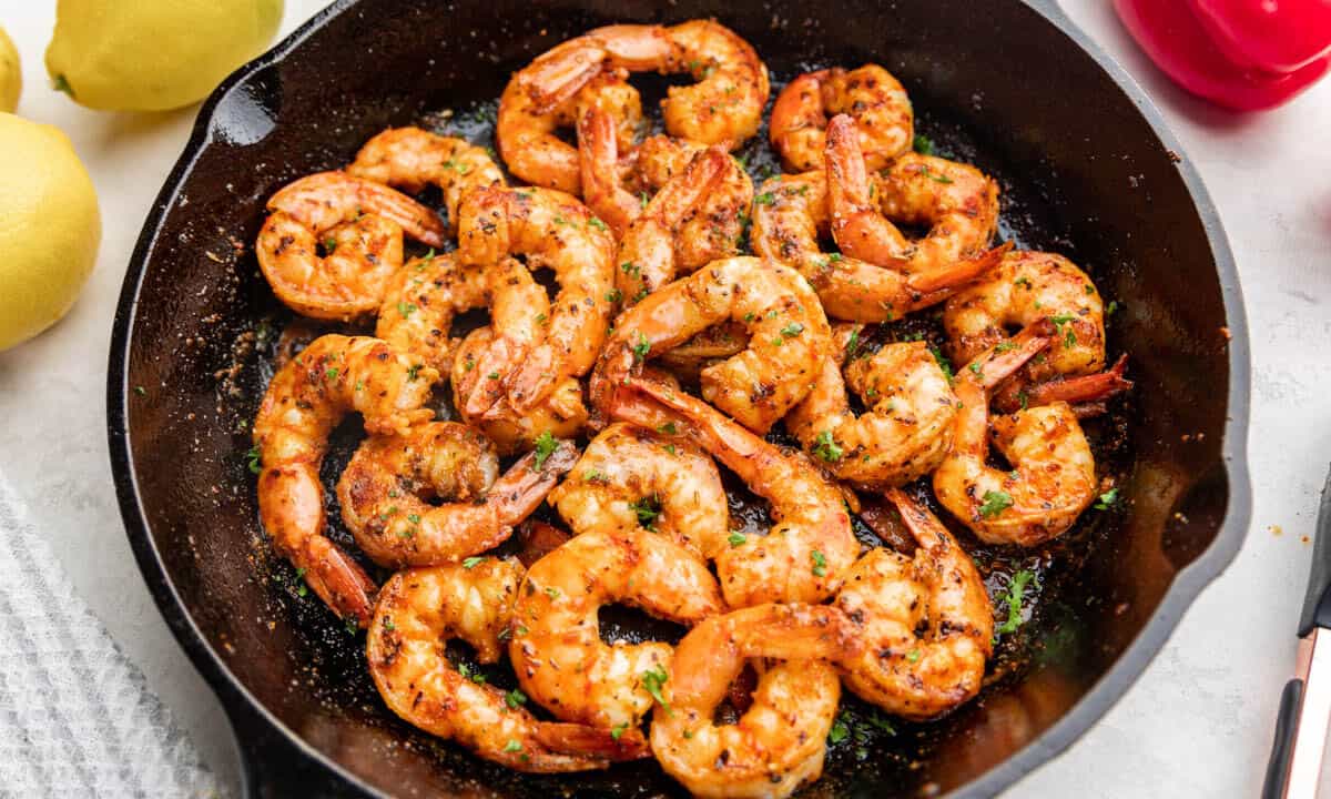 Overhead view of cajun shrimp on a black plate.