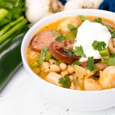 Cajun white chicken chili in a white bowl with sour cream