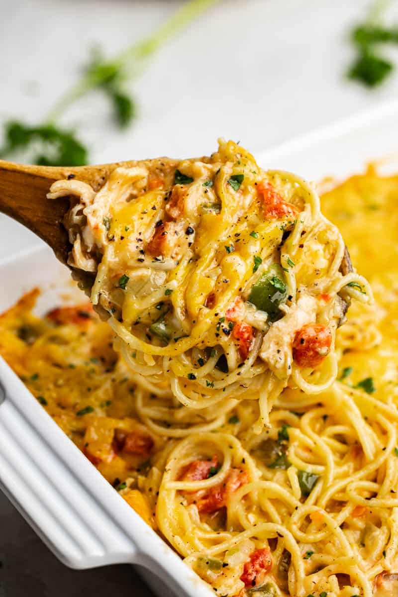 A close up view of a serving of chicken spaghetti being scooped out of the pan. 