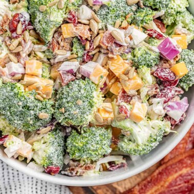 Overhead view of a large white bowl filled with classic broccoli salad.