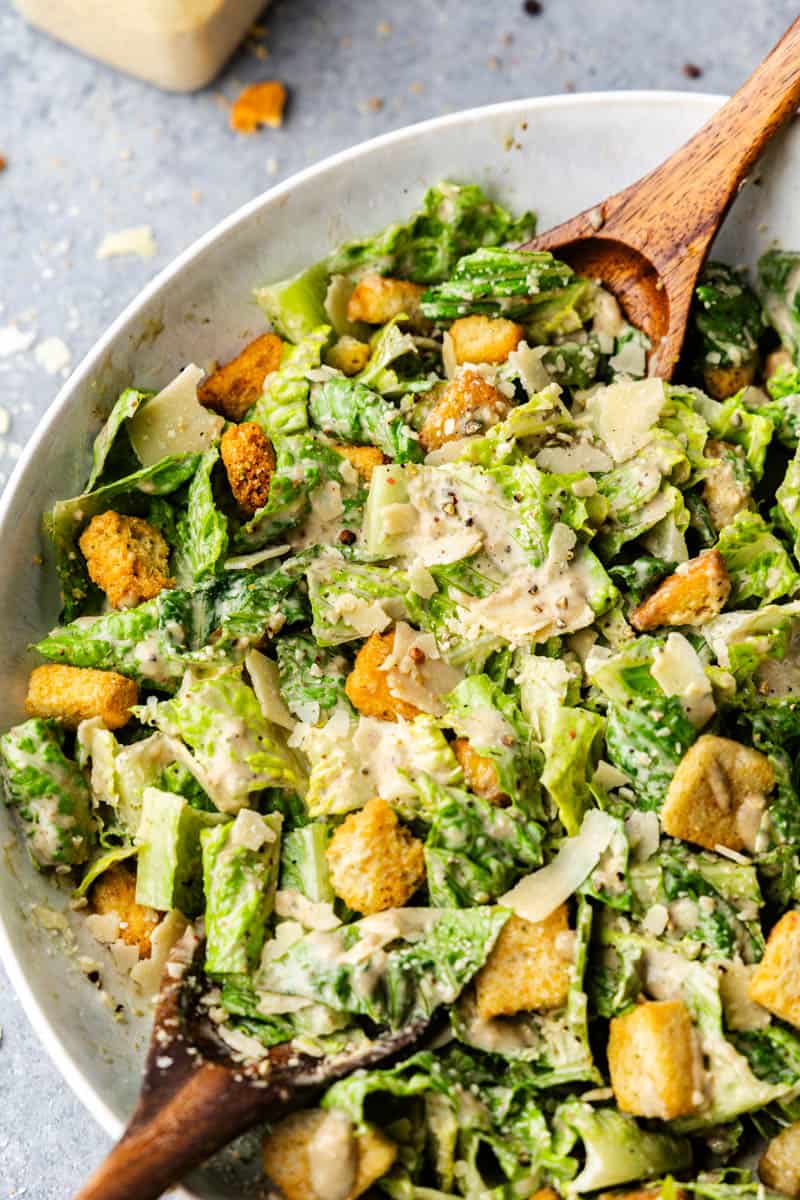 A bowl of Caesar Salad on a table.