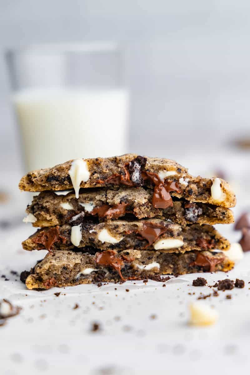 A stack of 4 cookies and cream cookies that have been broken in half.