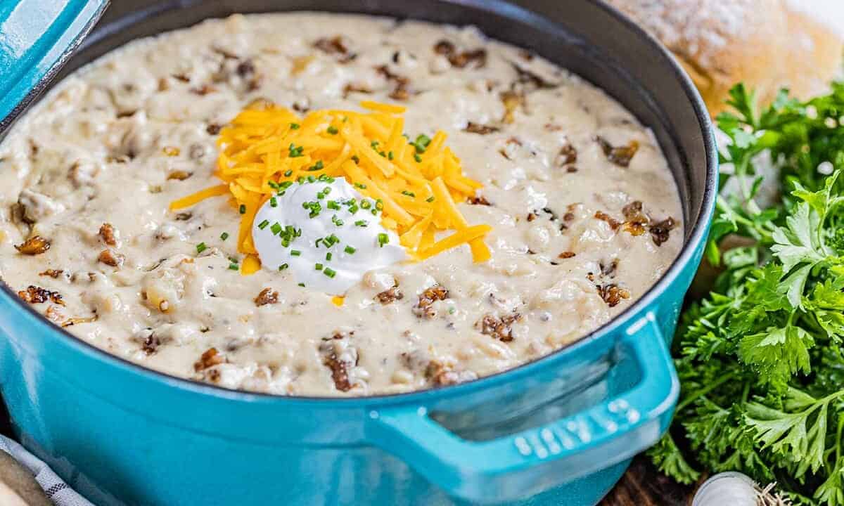 Close up view inside a pot full of creamy sausage potato soup.