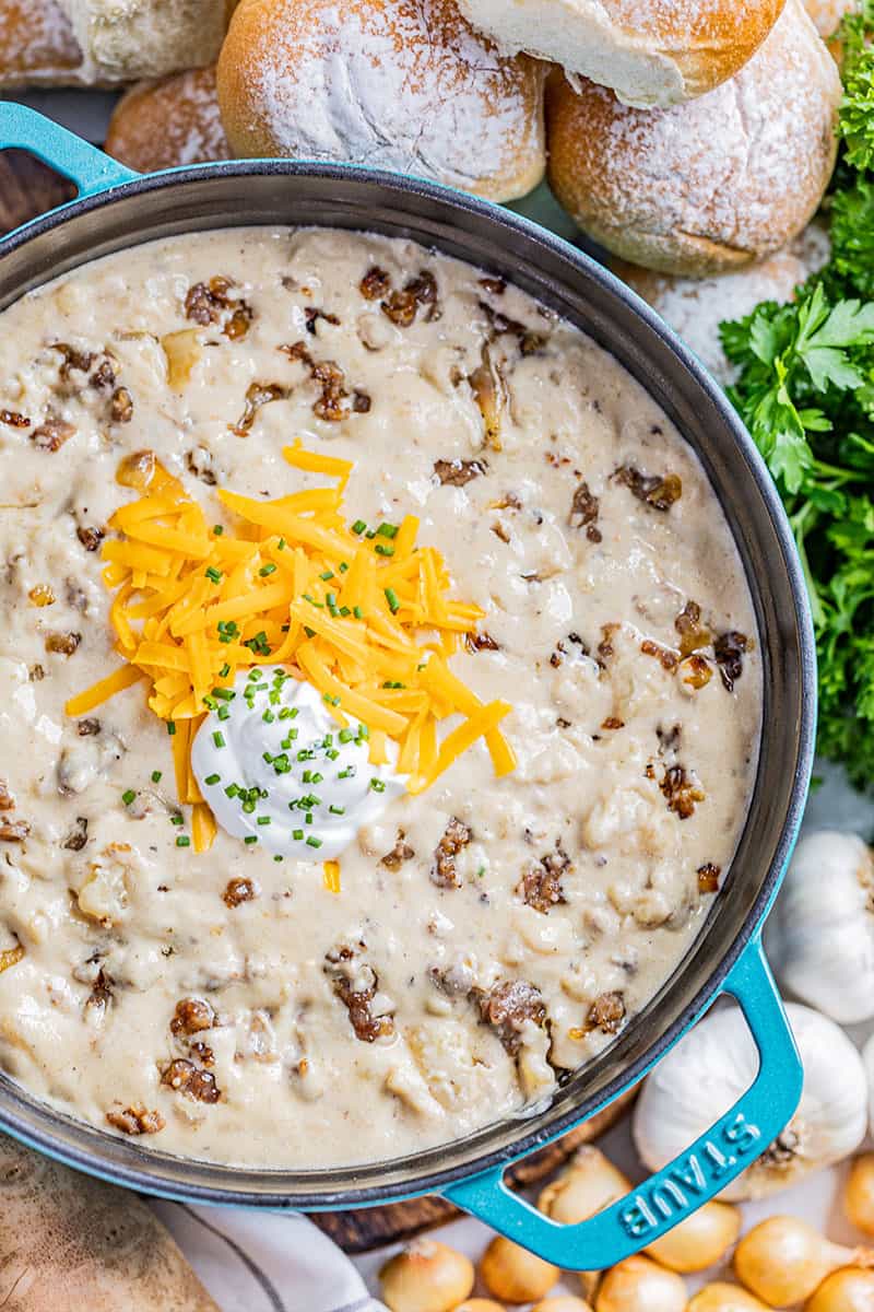 Overhead view into a large pot filled with creamy sausage potato soup.