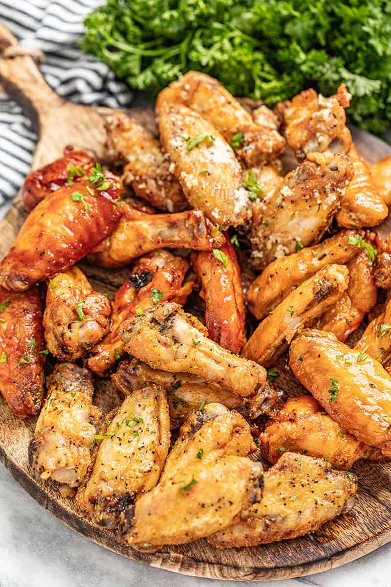 A serving board full of crispy oven baked chicken wings