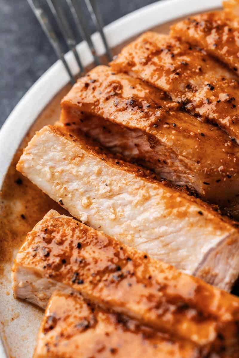 Overhead view of sliced pork chops on a dinner plate.