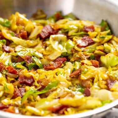 Fried Cabbage and bacon mixed together in a stainless steel bowl.