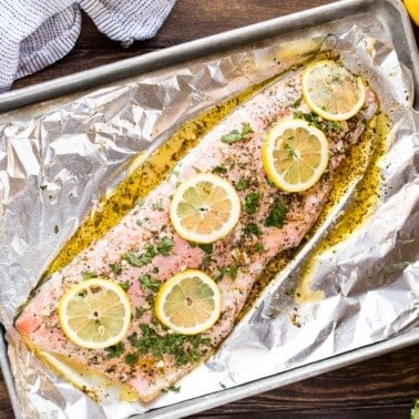 Birrd's eye view of baked garlic herb salmon on a baking sheet.