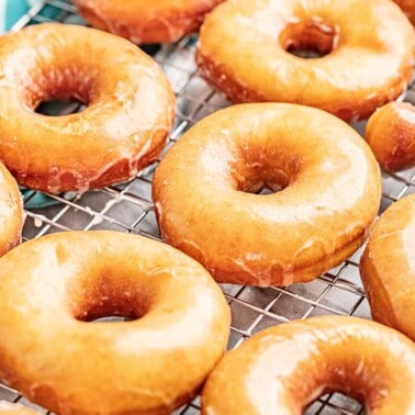 Homemade glazed donuts and donut holes on a cooling rack