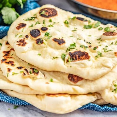 Stack of 5 pieces of naan bread on a blue towel