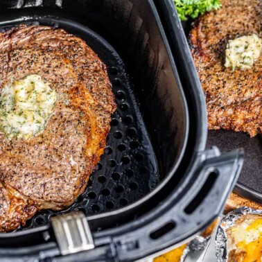 Overhead view of a cooked steak in an air fryer.