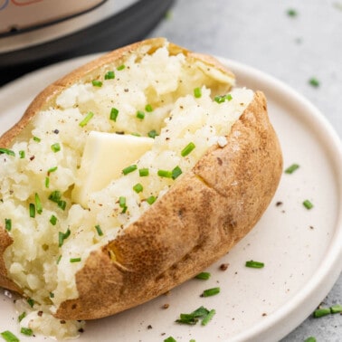 A baked potato on a plate that was baked in an instant pot.