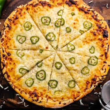 An overhead shot of a full Jalapeno Scalloped Potato Pizza cut into slices.