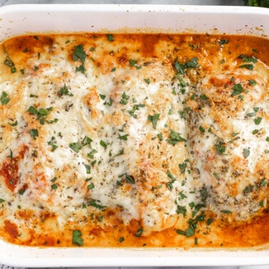 Lasagna stuffed chicken in a casserole dish.