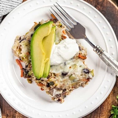 A serving of brown rice and black bean casserole on a plate.