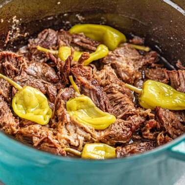 Mississippi pot roast with pepperoncinis in a teal dutch oven