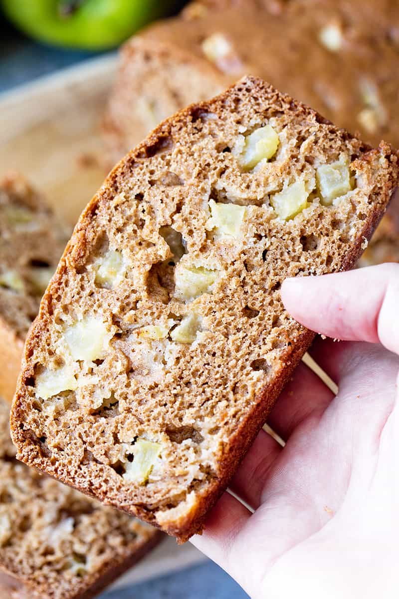 Hand holding a slice of apple bread