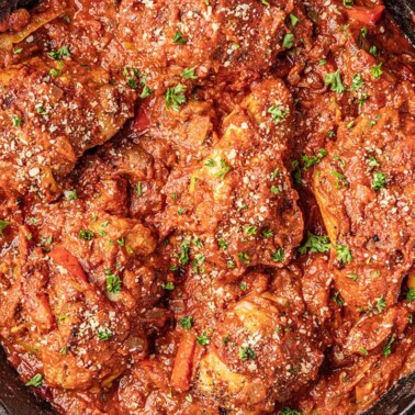 Bird's eye view of Chicken Cacciatore in a cast-iron skillet.