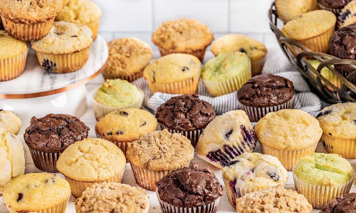 A lot of muffins all over a countertop.