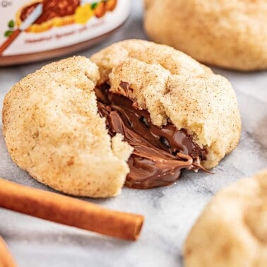 Churro cookie broken in half with chocolate melting out from the middle