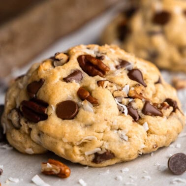 A thick and soft cowboy cookie on a parchment lined baking sheet.