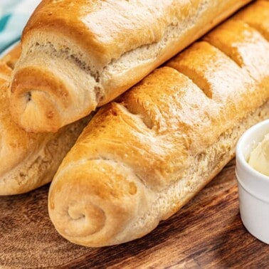 3 loaves of French bread and fresh butter in a ceramic dish