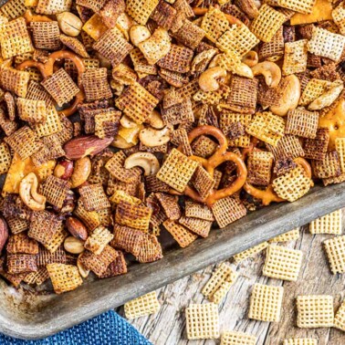 Overhead view of party Chex mix on a baking sheet.