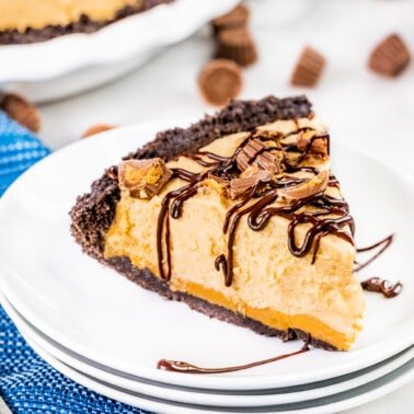 A slice of peanut butter pie on a stack of dessert plates.