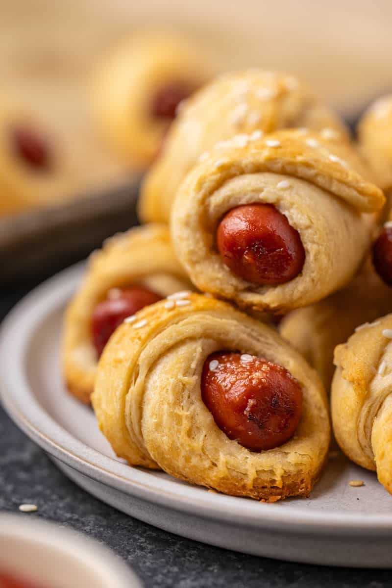 Close up view of pigs in a blanket on a dinner plate.