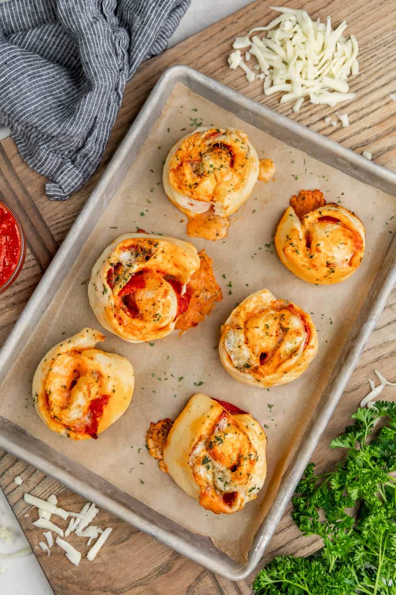 Overhead view of pizza rolls on a baking sheet.