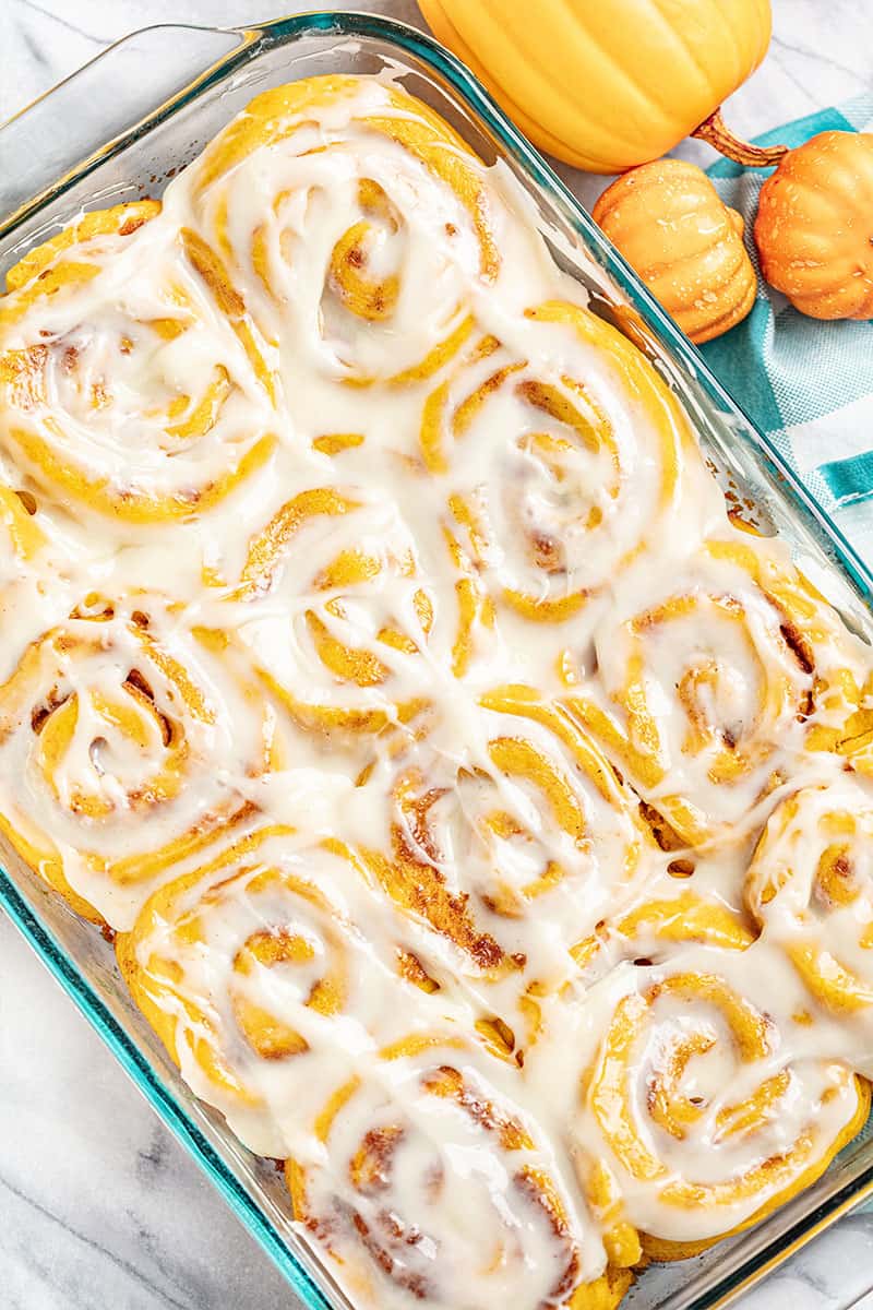 Bird's eye view of Pumpkin Cinnamon Rolls in a glass baking pan.