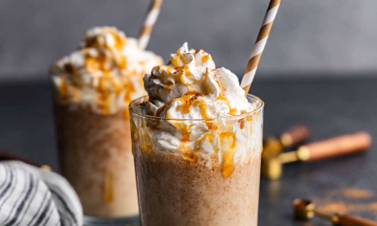 Two pumpkin spice frappes on a table.