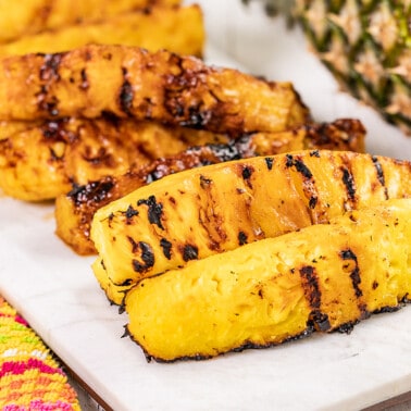 Grilled pineapple spears on a serving platter.