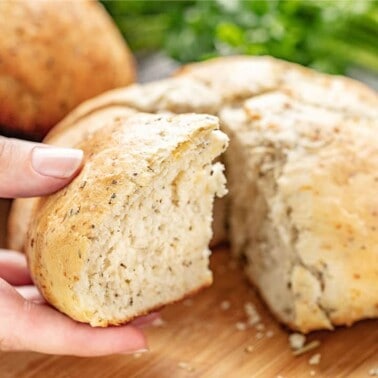 Rustic garlic parmesan herb bread, pulling a cut piece off