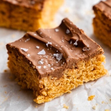 A close up view of a square of homemade scotcharoos, sprinkled in flaked salt.