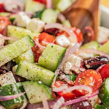 A close up view of a serving bowl filled with greek salad.