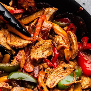 A closeup overhead view of chicken fajitas in a skillet.