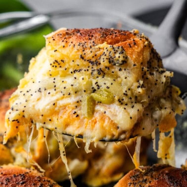 A southwest turkey slider on a hawaiian roll being lifted out of the pan.