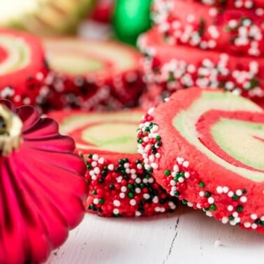 Spiral Christmas sugar cookies with a Christmas ornament.