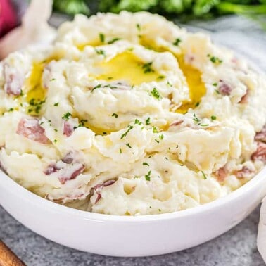 Steakhouse style garlic mashed potatoes in a white bowl.